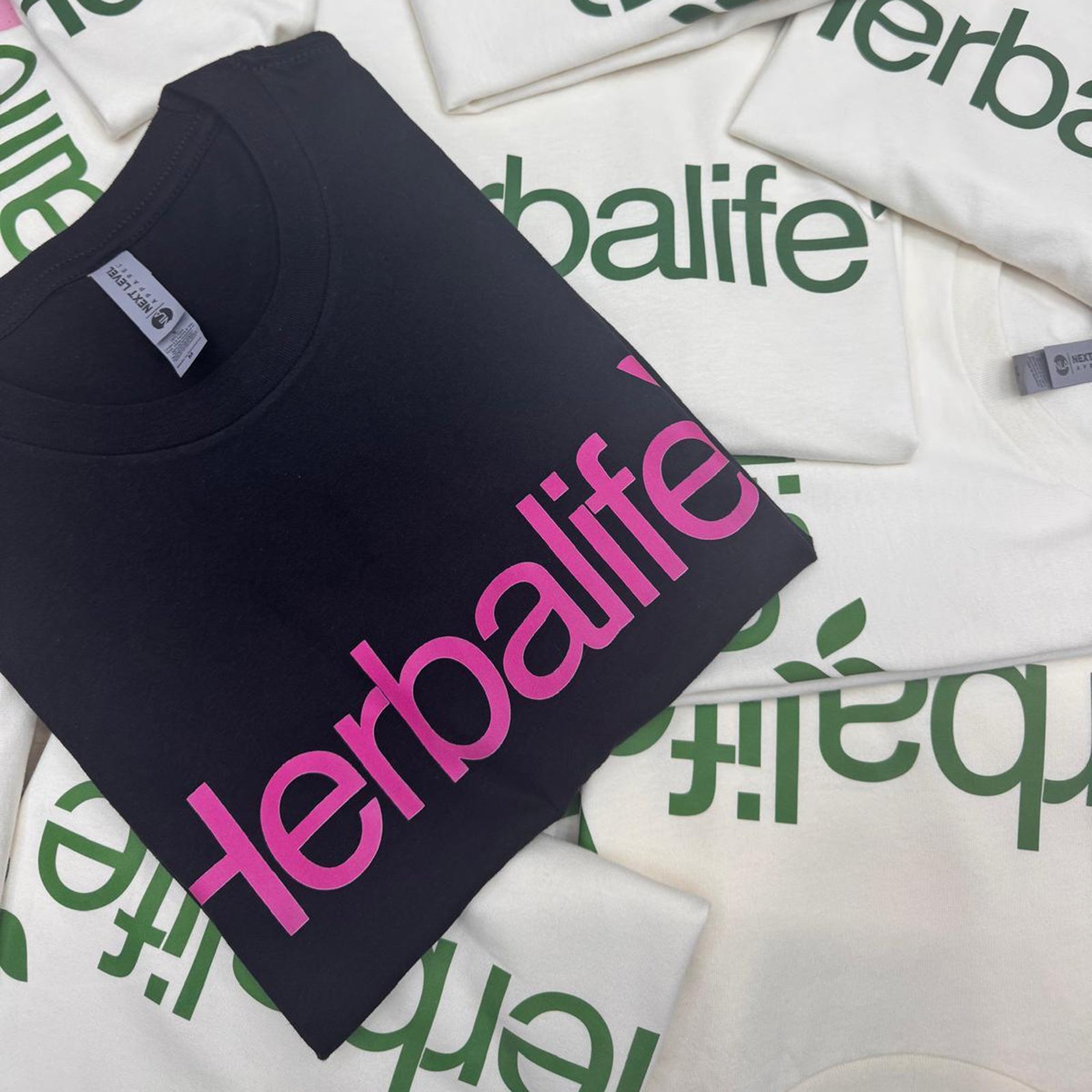 folded white and black Tshirts printed with direct to film with  herbalife loo